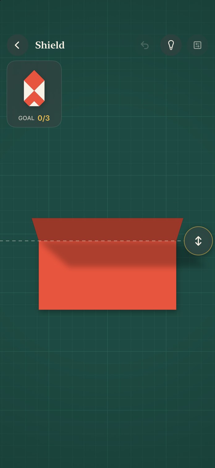 The puzzle Shield in progress: a coral sheet on the cutting mat, mid-fold, with the target shape in the corner